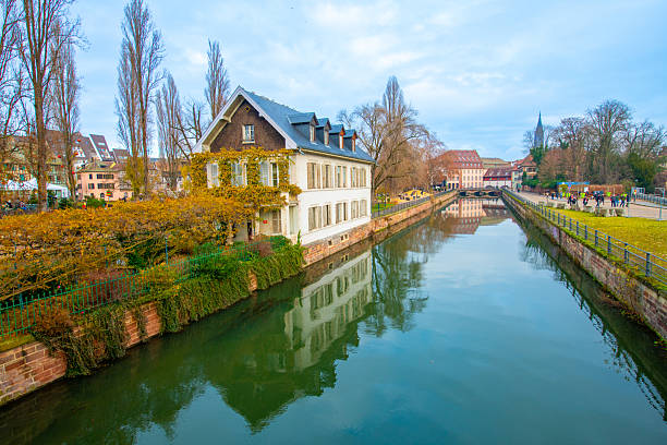 Strasbourg, France - December 5, 2025: Beautiful travel landscape with half-timbered houses on the banks of the river ill and decorated flowers in Strasbourg. France quarter in Strasbourg.