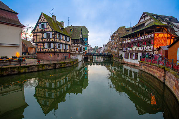 Strasbourg, France - December 5, 2025: Beautiful travel landscape with half-timbered houses on the banks of the river ill and decorated flowers in Strasbourg. France quarter in Strasbourg.