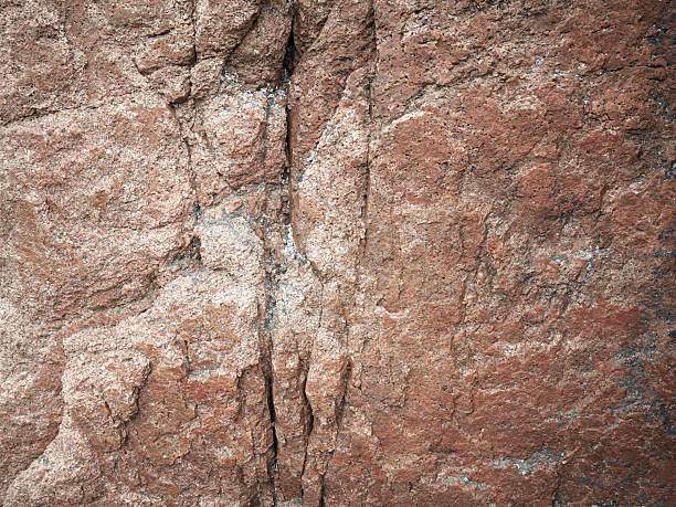 Red natural granite stone, texture of cracked pattern, full frame