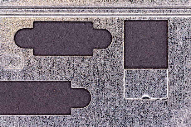 Textured metal plate showing geometric cut-outs with dark background