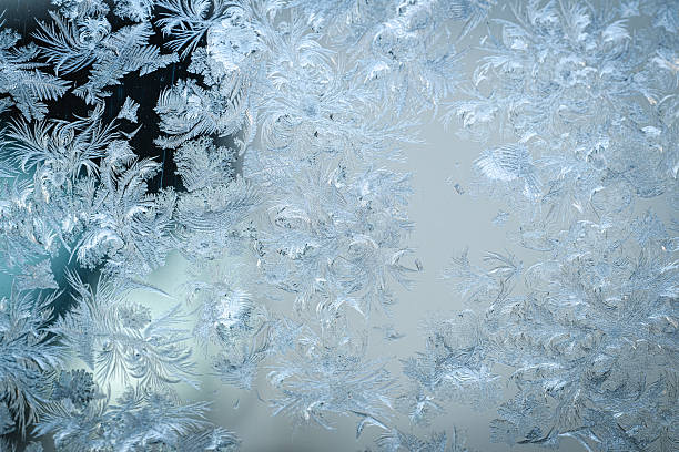 Beautiful frost pattern on a window in blue tones. Can be used as a winter / holiday background.