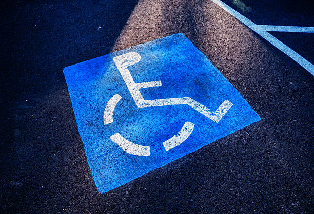 Painted blue and white handicap packing symbol on a parking space in a parking lot.