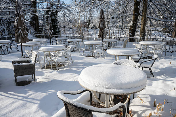 Clinton, USA - January 19, 2026. Outdoor chairs and tables of Riverside Coffee & Tea covered with snow, Clinton, New Jersey, USA