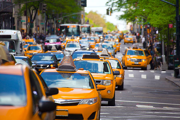 Defocused city road from above with taxi car and traffic jam on highway with warm light, blurred colored bokeh postcard of metropolis with a traffic light grid.