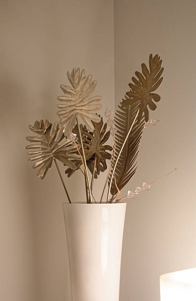 Metallic Artificial Leaves Arrangement in Tall White Vase