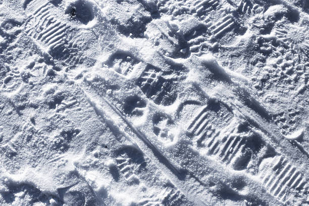 istock Snow surface with footprints and shoe tread marks. Winter ground texture closeup. 2258225024