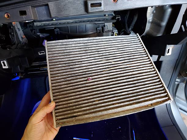 Hand Holding a Dirty Cabin Filter from a 2010s Car. High quality photo