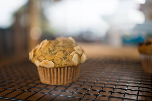 Delicious banana flavored cupcake with nut slices on black grille