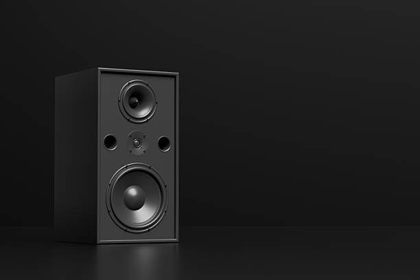 Black audio speaker standing on a dark minimalist background, representing music, sound, technology, and entertainment