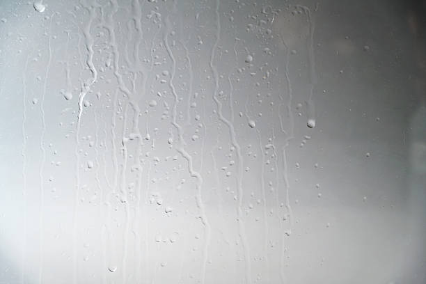 Water droplets condensation background of dew on glass window, humidity and foggy blank background. Outside the window, bad weather, rain