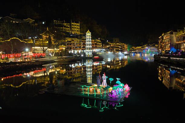 Gubeikou water town, China, with traditional architecture and willow trees lining the canal, tourist boats carrying visitors enjoying a sunny day, exploring historical culture and local heritage