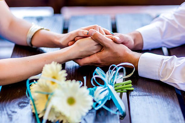 People joining hands in celebration with flowers and gift ribbons