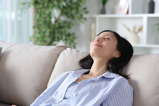 istock Relaxed asian woman resting on a comfortable couch 2258259425