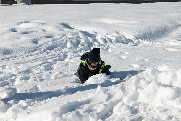 A boy plays in deep snow during a blizzard.
