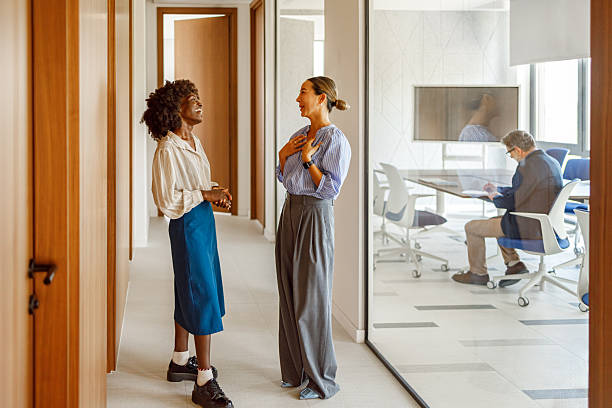 istock Female coworkers enjoying friendly conversation while collaborating in a professional office corridor 2258269994