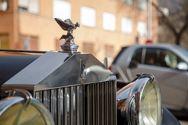 A classic black Rolls Royce, with its Spirit of Ecstasy emblem, parked in the city of Madrid on Serrano Street, known as the Golden Mile.