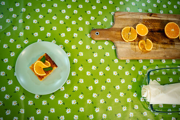 Orange phyllo pastry cake serving on a colorful floral tablecloth