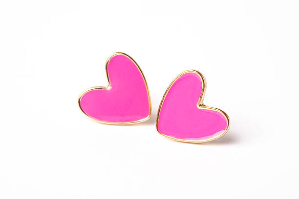 Pink heart earrings on white background