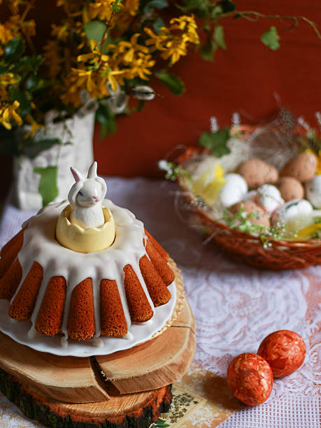 Easter cake decorated with ceramic bunny and eggs on festive table. Concept of Easter tradition, holiday food styling, seasonal background for banner, social media, retail use.
