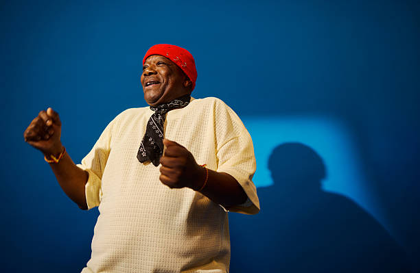 Senior man smiling and dancing with energy against a blue background