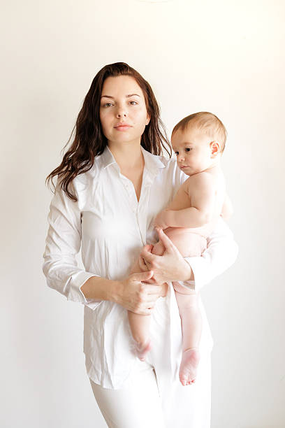 Mother holding her baby on white background studio photo
