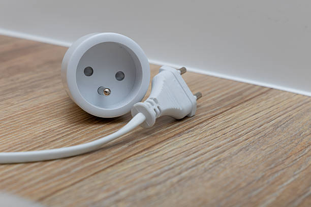 istock A plug with a cable placed on a wooden floor, a smart electrical outlet controlled by a phone, the Internet of Things, 2258299298
