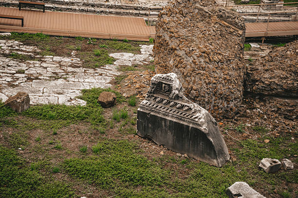 Ancient Roman Ruins with Stone Fragment and Grass at Archaeological Site