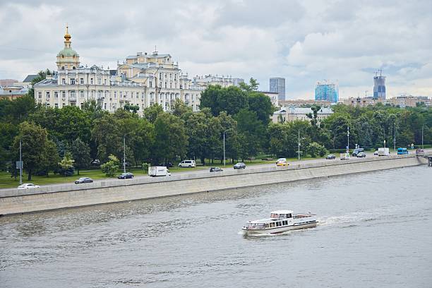 Moscow, Russia, September 28, 2023: Tour boat on the Moskva River and old architecture on the riverbank on a clear day