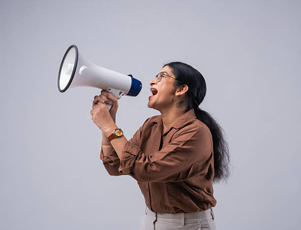 istock Businesswoman shouting over megaphone and protesting on white background 2258307394