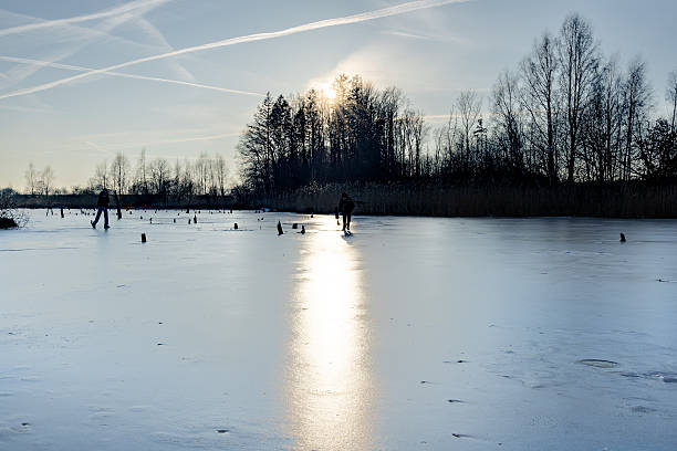 Frozen overflown floodplains of the Zwarte Water river between Zwartsluis and Hasselt during a beautiful cold winter day on Januari 10, 2024. Ice skating on natural ice is an old tradition in The Netherlands and a popular leisure activity whenever it's cold enough for lakes and rivers to freeze over.
