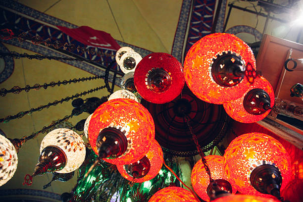 Close-up view of colorful decorative lanterns hanging in a traditional market, showcasing craftsmanship and vibrant patterns.