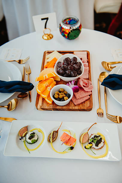 Elegant dining with delicacies. A beautifully arranged table features a variety of meats, cheeses, fruits, and spreads, perfect for a gourmet meal.