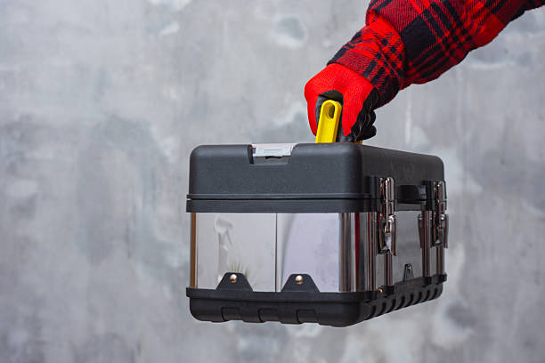 Worker wearing protective gloves holding metal toolbox for repair, construction and maintenance work. Concept of professional service, technical support, home improvement and industrial craftsmanship