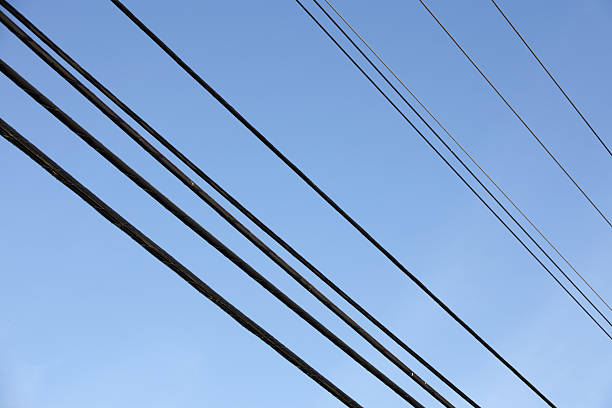 Low angle view of rows of power lines over 159A Street in the Fleetwood neighbourhood of Surrey, British Columbia, Cold winter morning with a clear sky over Metro Vancouver.