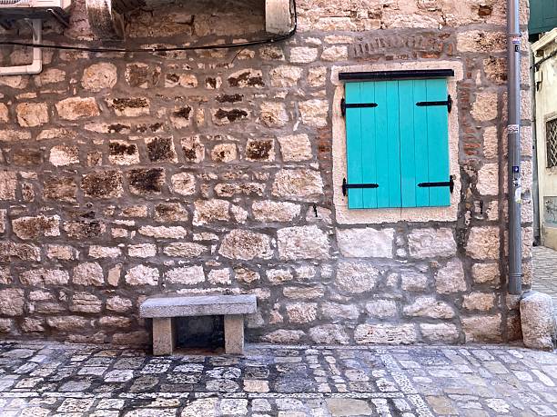 Brightly painted facades in sun-washed yellows, blues, and terracottas line the narrow stone streets of old Rovinj, climbing gently toward the hilltop like a living mosaic. Weathered shutters, trailing flowers, and timeworn textures give each building its own quiet story, blending Adriatic warmth with centuries of history.