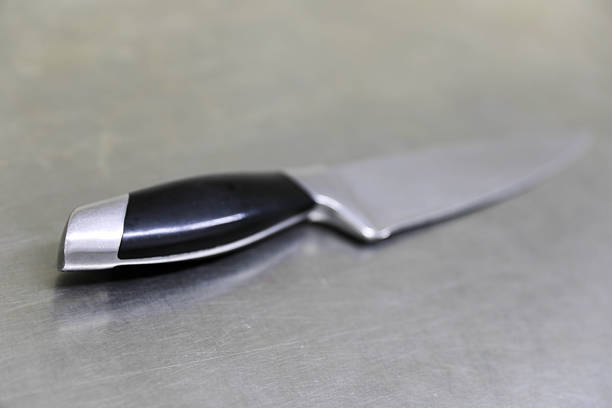 An evocative image highlighting a rugged, aged machete gripped tightly in a strong hand. The contrast against the white background draws focus to the texture of the worn blade and the firm grip, symbolizing labor, survival, and resilience. Perfect for themes of craftsmanship, endurance, and manual work.