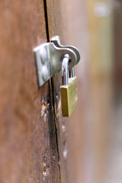 Close Up of a Metal Padlock Securing a Wooden Door, Representing Security, Protection, Privacy, And Access Control Concept With Shallow Depth of Field.