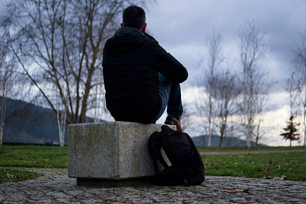 Voronezh Russia January 02.2025. A man sits on a bench alone in front of the river