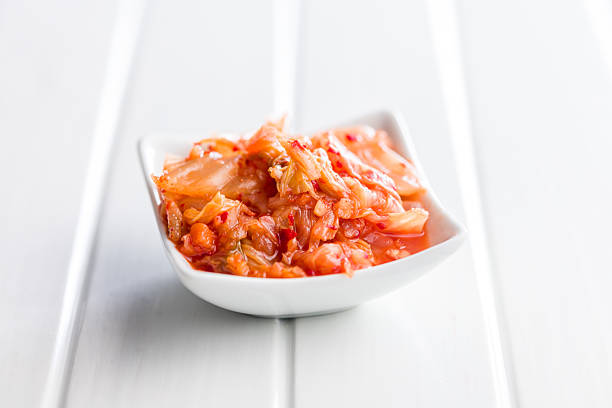 Fermented cabbage. Kimchi. Korean food in bowl on a white table.