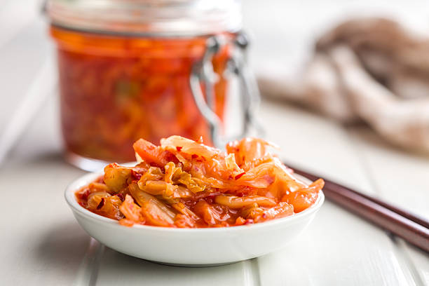 Fermented cabbage. Kimchi. Korean food in bowl on a white table.