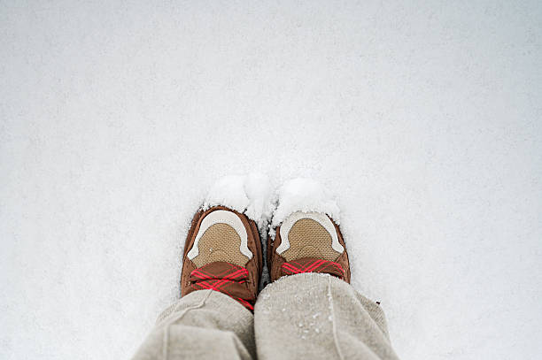 Hiking trail in winter should wear Crampons snow spike on shoes to protect slippery on ice icy surface road. Crampon spike shoe walk good on snow, blue sky background isolated