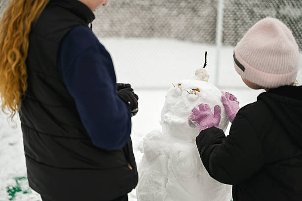 Vologda, Russia - February 15, 2025. Artists carve ice sculptures outdoors in a city square