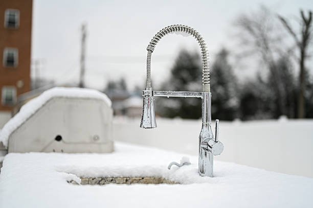 Outdoor kitchen faucet covered in fresh snow on a cold winter day
