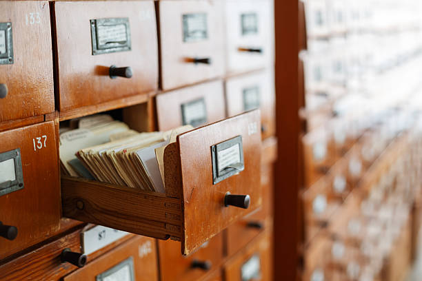 Vintage library card catalog drawer opening, revealing archival index cards for research