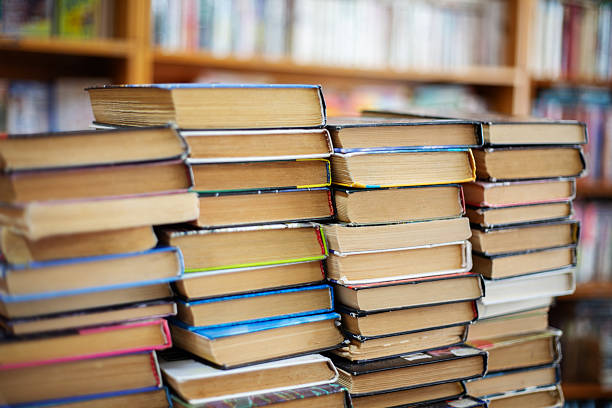 Stacks of old books with weathered pages in a library or bookstore setting