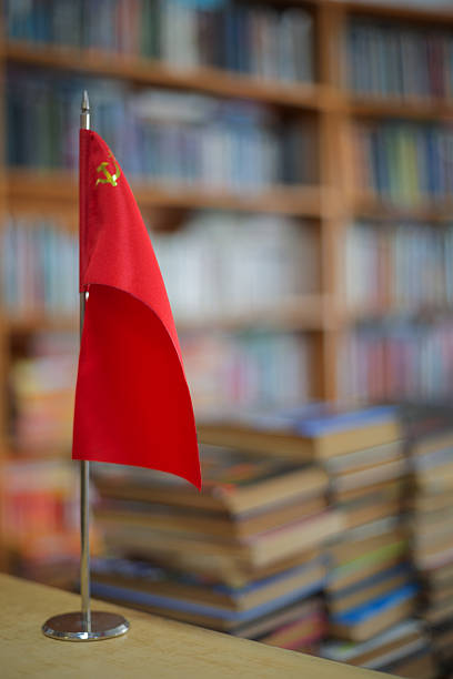 USSR flag banner on a stand with blurred books in a library, representing history and communism
