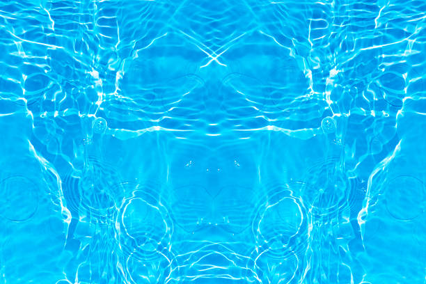 Close-up view of rippling blue water with sunlight reflections on a swimming pool surface, creating a calming abstract pattern.