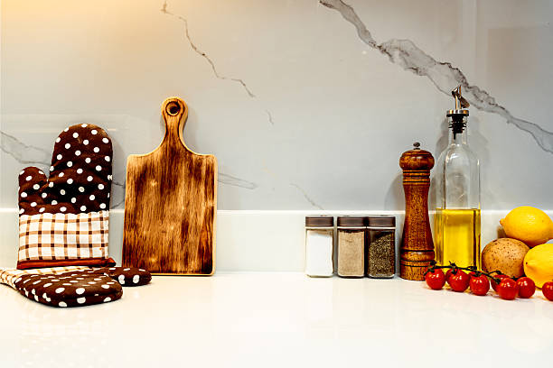 White kitchen table and tile wall with ingredients for healthy cooking, close-up, copy space.