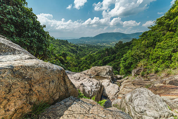 View from Na Muang Waterfall 2 on Koh Samui with rocky ledge, tropical jungle valley, distant coastline and sea horizon. High quality photo