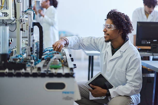 Happy African American male scientist working on machinery in laboratory.
